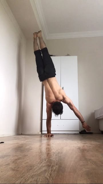 Orkhan holding a one-arm handstand